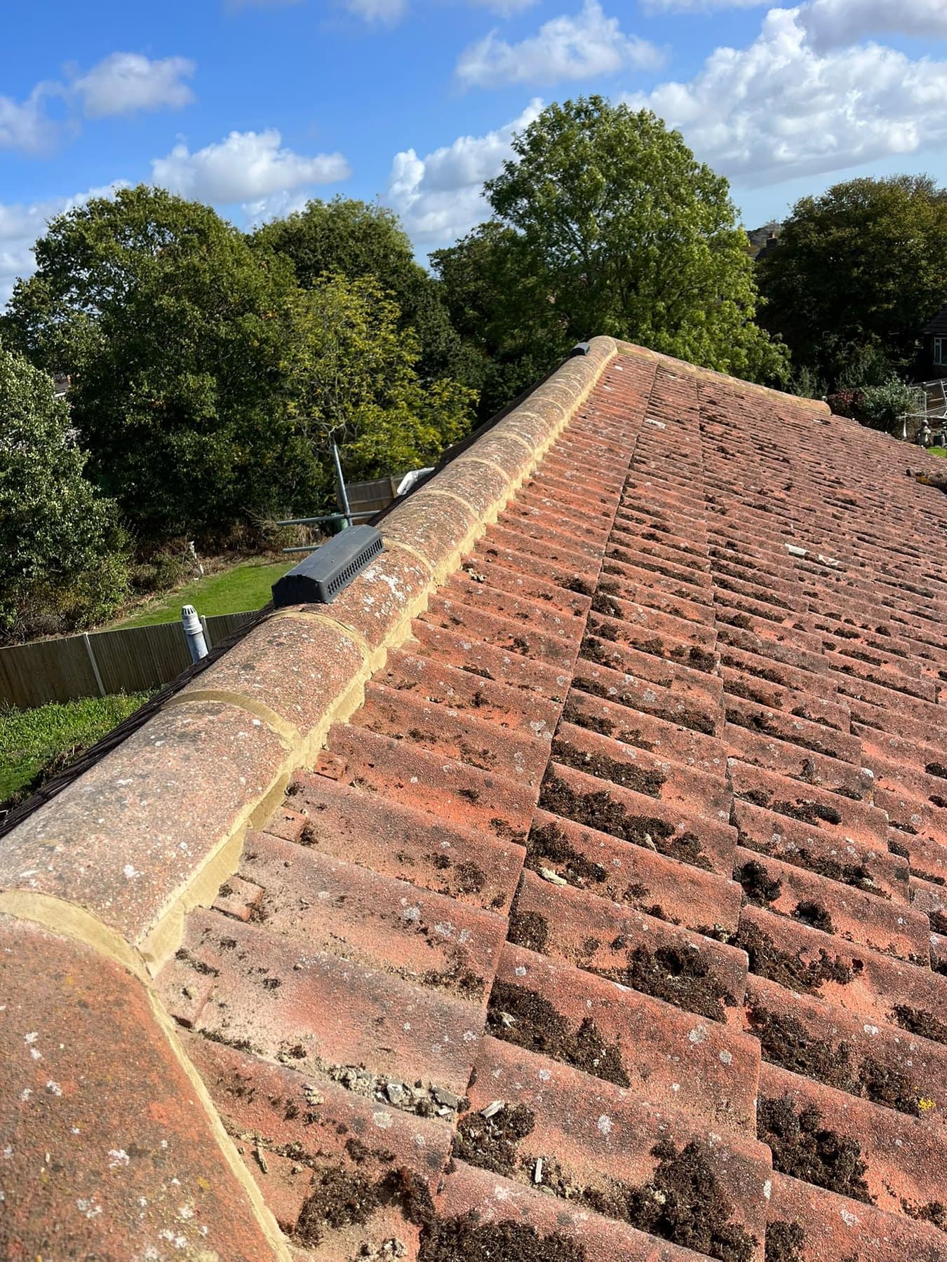 Ridge tiles rebedded in fresh mortar, with a ridge vent